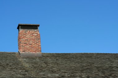 Old roof and chimney with blue sky clipart