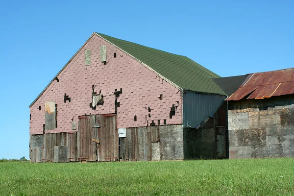 Old barn with grass and blue sky — Stok fotoğraf