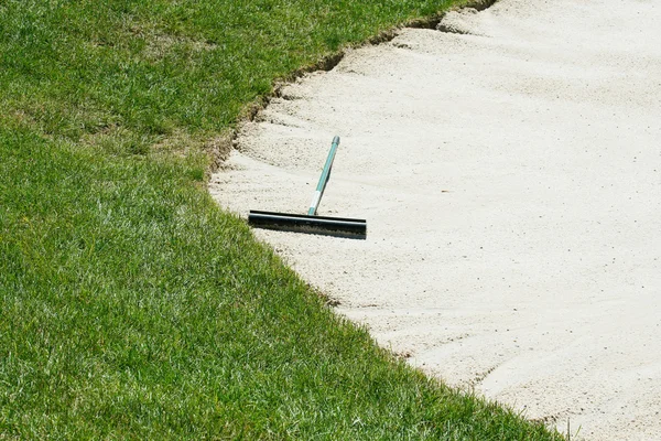 Sand trap rake in a bunker — Stock Photo, Image