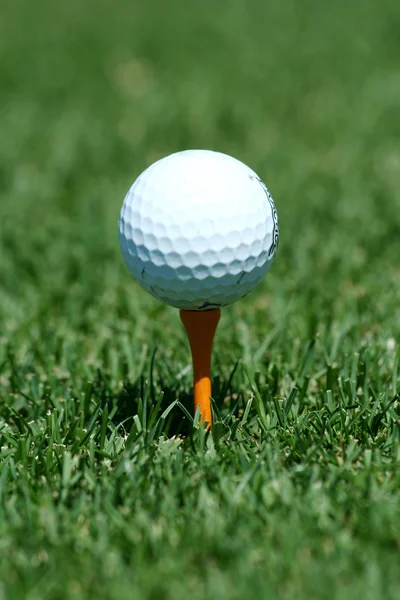 白色高尔夫球在球棒上橙色的三通 — 图库照片