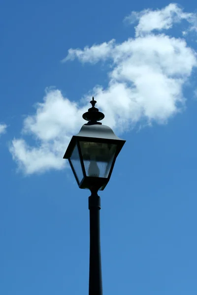 Чёрный фонарный столб против голубого неба — стоковое фото