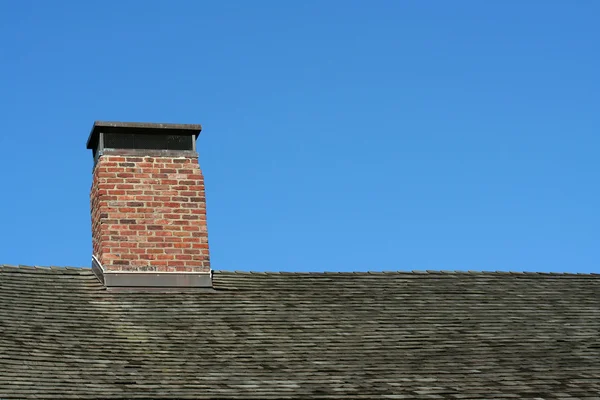 Старий дах і димохід з блакитним небом — стокове фото