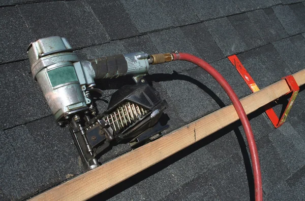 空気圧の屋根ふきの釘銃 ストック画像