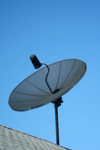 Чорна супутникова тарілка на фоні блакитного неба — стокове фото