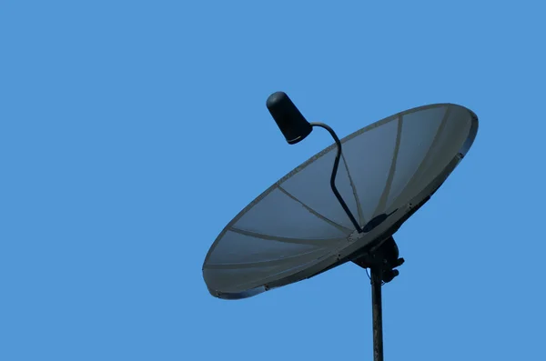 Antena parabólica preta contra um céu azul — Fotografia de Stock