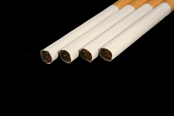 Изолированная сигарета на черном фоне — стоковое фото