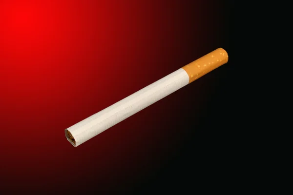 Ізольована сигарета на червоному — стокове фото