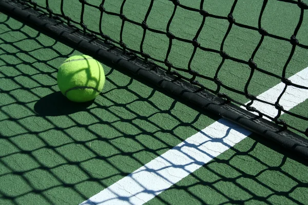 Tennis ball near net — Stock Photo, Image