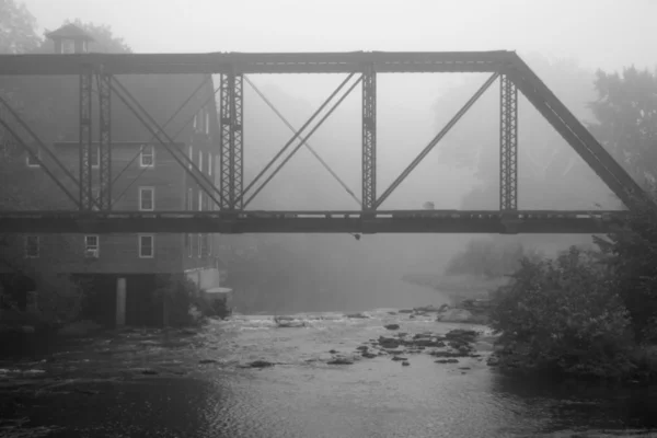 Старая мельница и мост в туманное утро — стоковое фото