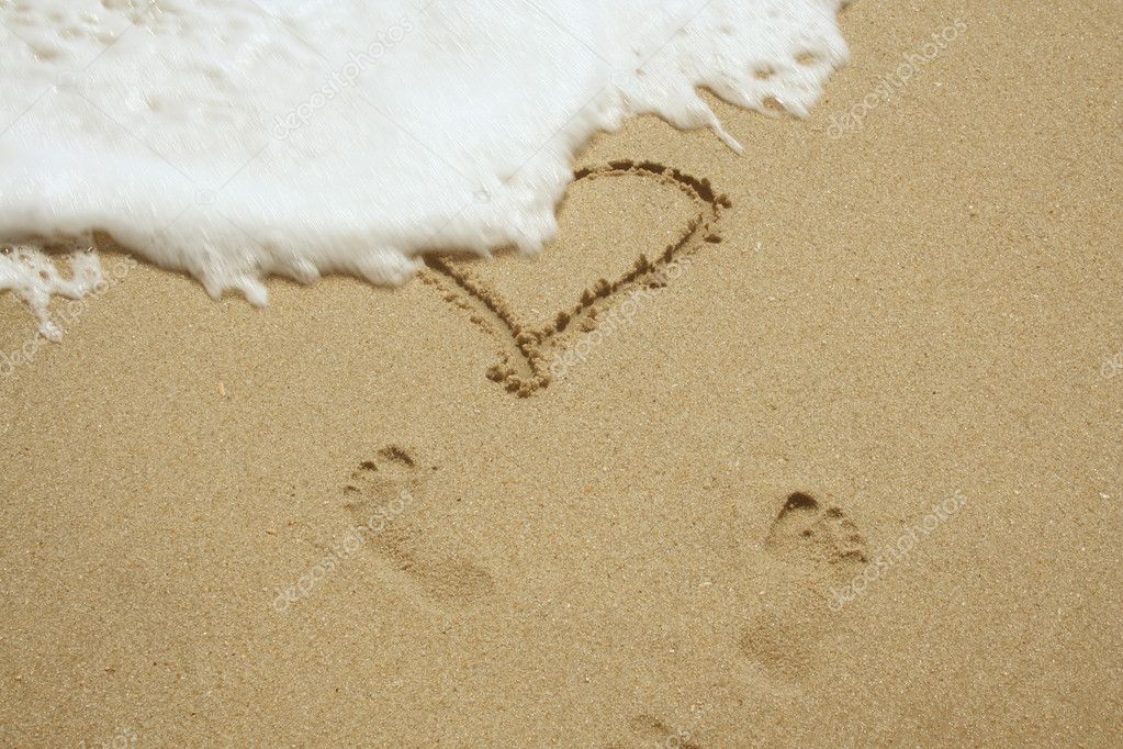 Heart and footprints in sand
