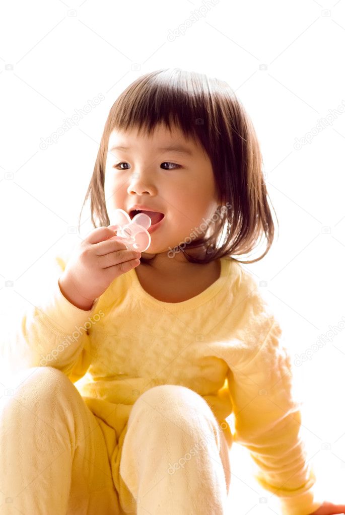 Lovely Asian baby sit and suck pacifier