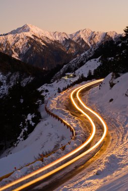 Car light in night on ice road clipart