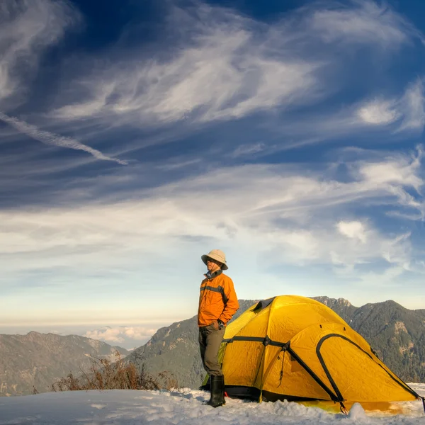 Человек стоит с желтой палаткой — стоковое фото
