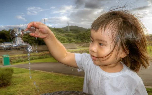 Baby tvätta hennes hand i utomhus — Stockfoto