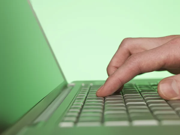 Fechar em uma mão que escreve em um computador portátil — Fotografia de Stock