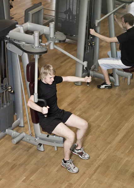 Ung man med en träningsmaskin — Stockfoto