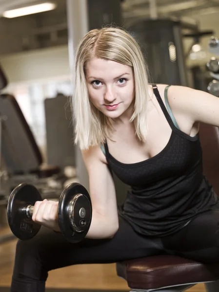 Junge Frau stemmt Gewichte — Stockfoto