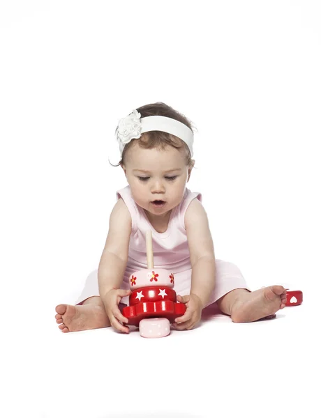Baby in pink clothes playing — Stock Photo, Image
