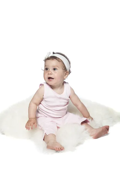 Baby sitzt auf einem Schaffell — Stockfoto