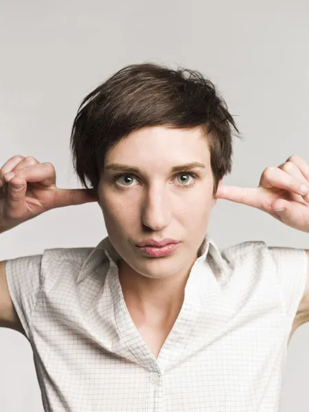 Vrouw met vingers in haar oren — Stockfoto