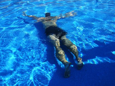 Man swimming underwater in pool clipart