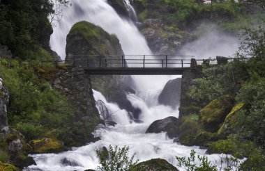 Bridge across the stream near waterfall clipart