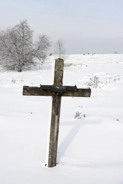 stock image Catholic cross on a snowy meadow