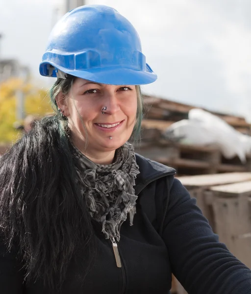 Mulher trabalhadora sorridente em chapéu azul duro — Fotografia de Stock