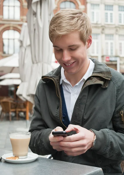 Knappe jongeman texting een bericht — Stockfoto