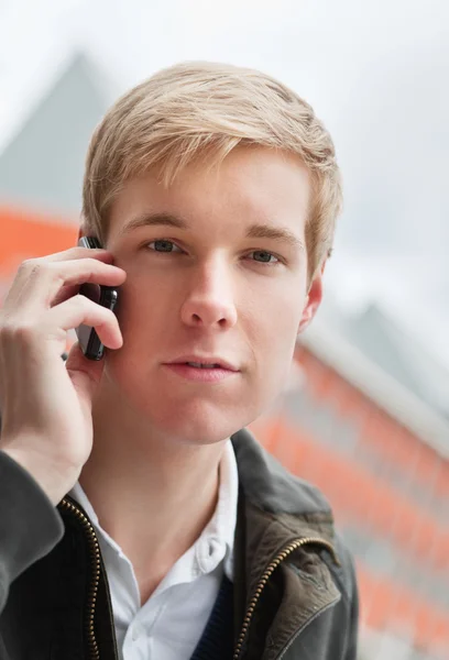 Komea nuori mies matkapuhelimen kanssa — kuvapankkivalokuva