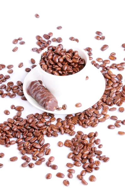 Scattered coffee beans around cup — Stock Photo, Image