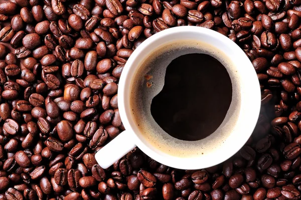 Чашка кофе на фоне кофе — стоковое фото