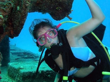 Female scuba diver posed underwater on a shipwre clipart