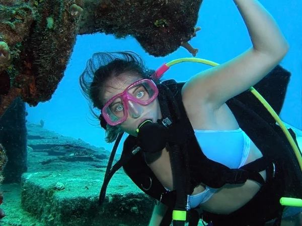 Kobieta scuba diver postawione pod wodą na shipwre — Zdjęcie stockowe