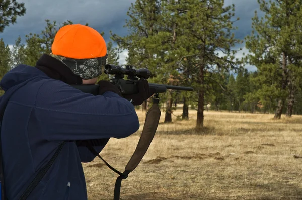 Jäger zielt mit Gewehr in den Wald — Stockfoto
