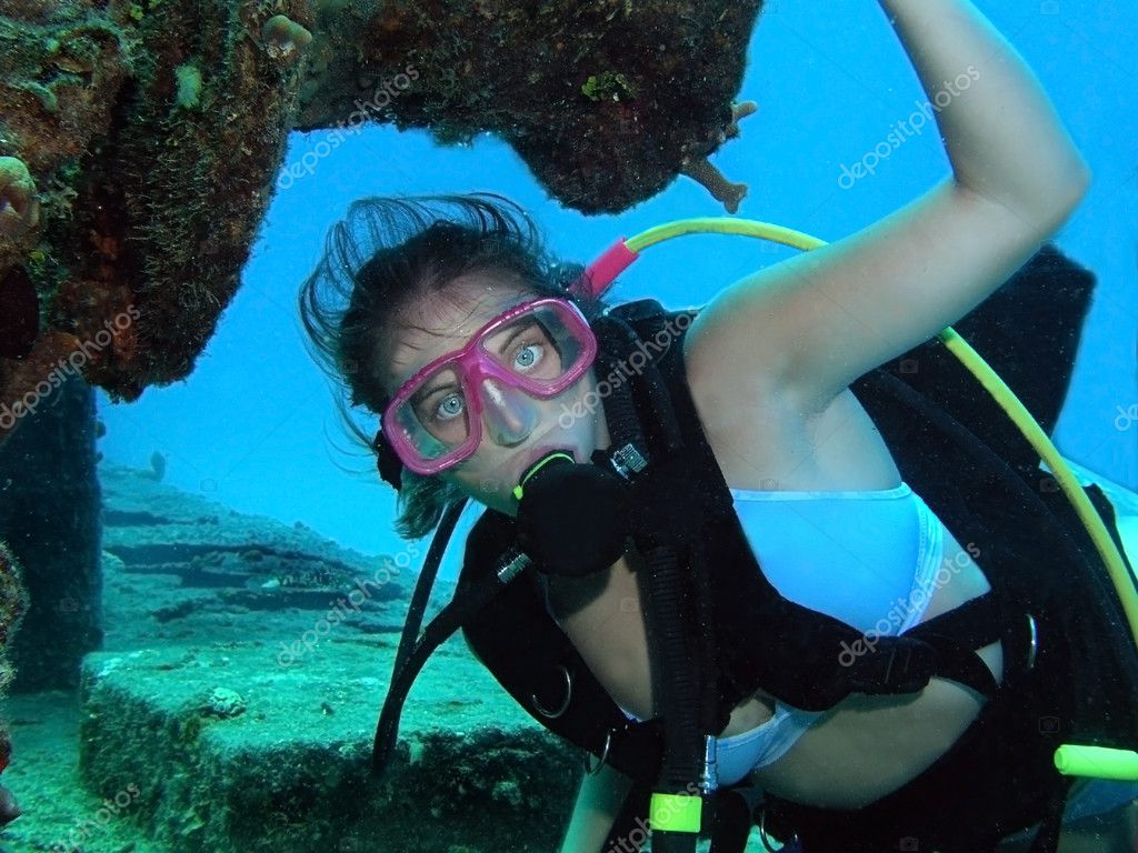 Scuba divers pose for the camera underwater. Stock Photo #65744095