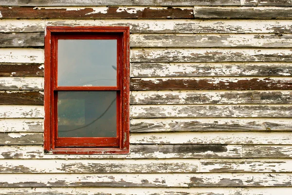 Oude rode venster in verf peeling gebouw — Stockfoto