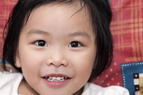 Ágyon ázsiai kislány — Stock Fotó