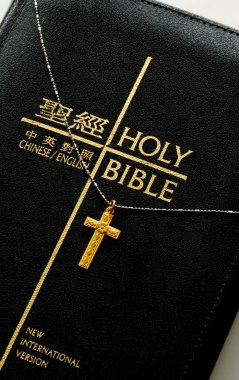 A golden cross on the top of the bible clipart