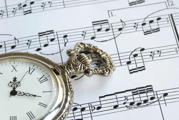 Antique pocket watch on the music sheet — Stock Photo, Image