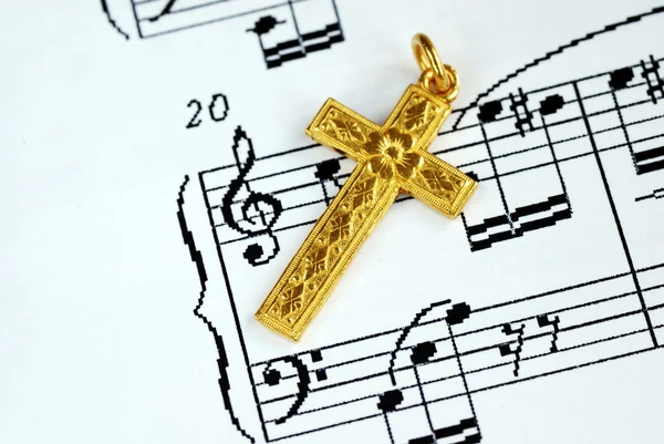 A golden cross on the music sheet — Stock Photo, Image