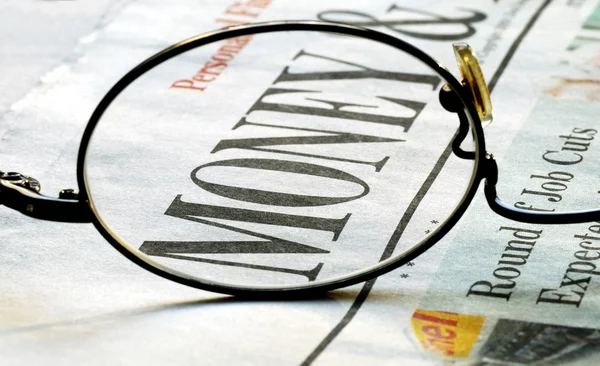 Fokusera på pengar investera på en tidning — Stockfoto