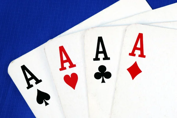 Quatro cartas de jogo de ás isoladas em azul — Fotografia de Stock