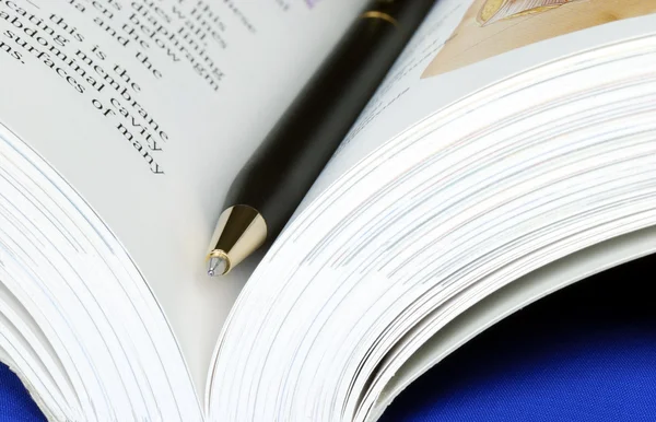 Ανοίξτε το βιβλίο με ένα στυλό που απομονώνονται σε μπλε — Φωτογραφία Αρχείου