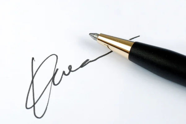 Подпишите имя на бумаге ручкой. — стоковое фото