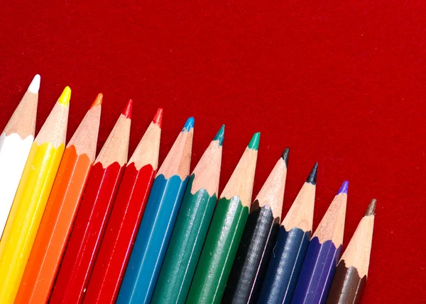 Χρωματιστά μολύβια που απομονώνονται σε κόκκινο — Φωτογραφία Αρχείου