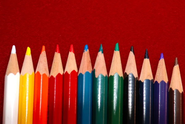 Χρωματιστά μολύβια που απομονώνονται σε κόκκινο — Φωτογραφία Αρχείου