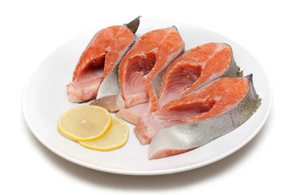 Trozo de pescado rojo con limón en el plato — Foto de Stock