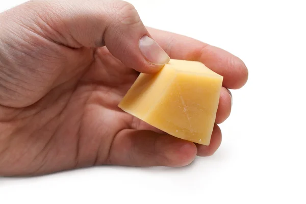 Pedaço de queijo na mão — Fotografia de Stock