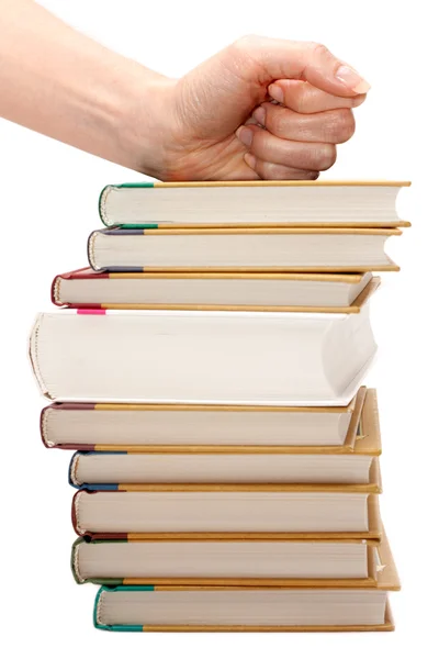 Женский кулак на стопке книг — стоковое фото